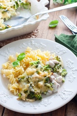 Baked broccoli with chicken on a plate with pasta on a wooden table, selective focus