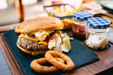 Tasty burger with beef, french fries and ketchup on plate. Fast food fries and cheeseburger