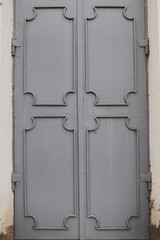 old gray metal door with wrought iron elements