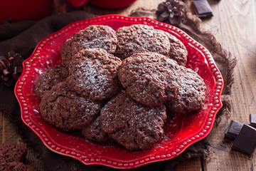Chocolate plain cookies on a red plate on a wooden table, selective focus