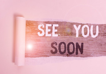 Handwriting text See You Soon. Conceptual photo used for saying goodbye to someone and going to meet again soon Cardboard which is torn in the middle placed above a wooden classic table