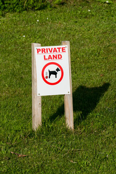 Hinweis Schild auf dem Rasen, Hunde hier nicht scheißen, mit der englisches Aufschrift PRIVATE LAND
