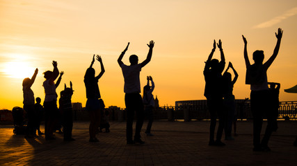 Unrecognizable people silhouette dancing on city festival at sunset. Street dance, holiday, summer and urban culture concept