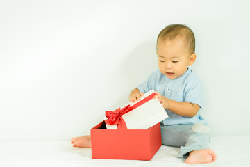 Little baby boy smile and holding red gift box on white background.child holding gift box.