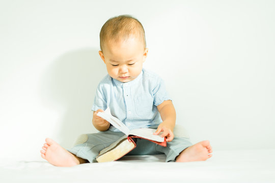 Cute asian baby boy read on a Holy Bible for faith and bible study and teach kid in the way of GOD.Concept for faith, spirituality and religion.