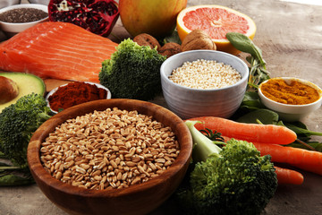 Healthy food clean eating selection: fish, fruit, vegetable, cereal, leaf vegetable on rustic background