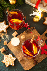 Winter Christmas mulled wine with orange and spices on the festive table. Top view flat lay background.