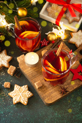 Winter Christmas mulled wine with orange and spices on the festive table. Copy space.
