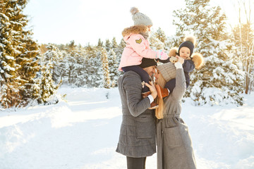 Family smiling in winter in a park