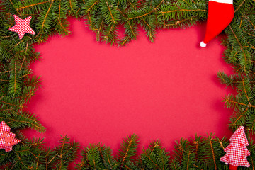 Tannenzweige als Rahmen, roter Hintergrund mit Weihnachtsdekoration