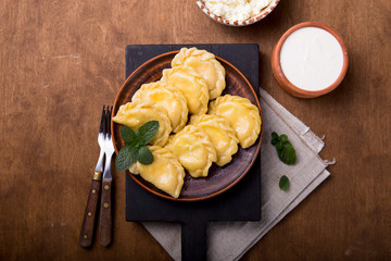 Ukrainian dumplings, pierogi or pyrohy, varenyky, vareniki, served with cottage cheese on board....