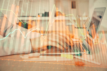 Double exposure of stock market graph with man working on laptop on background. Concept of financial analysis.