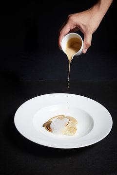 Hand Pouring Sauce Over Food On A Plate, Exquisite Dish, Creative Restaurant Meal Concept.