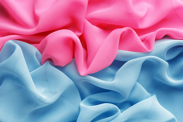 pink and light blue fabric with large folds as background