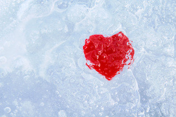 Red cold heart in ice. Close-up. Background. Texture.
