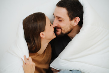 Close up portrait of a middle age couple sitting wrapped in a blanket, kissing