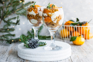 Citrus trifle with fresh tangerines. Christmas portioned dessert on the festive table.