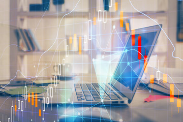 Financial chart drawing and table with computer on background. Double exposure. Concept of international markets.