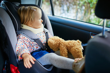 Adorable toddler girl in modern car seat