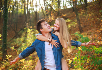 Happy couple guy and girl in forest park have fun together, people in love, concept of freedom and relationships