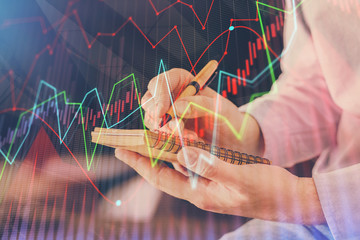 Double exposure hands with stock market chart.