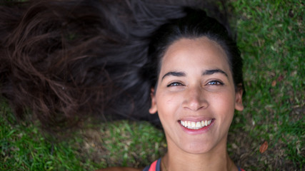 Fototapeta premium beautiful portrait of woman lying on the grass
