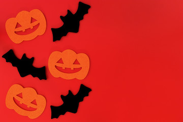Naklejka premium Halloween holiday decorations on red background, Flat lay of Halloween decorations on red, top view copy space, Halloween concept.