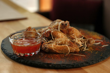 Tasty BBQ wings served on table in cafe