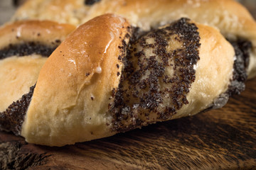 Bun with poppy seeds and honey on a wooden board. Shallow depth of field.