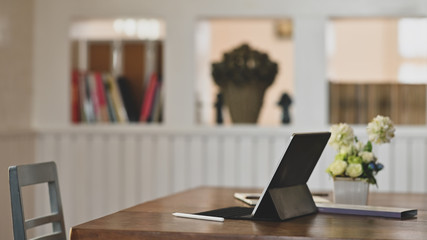 Digital tablet on wooden table.