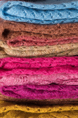 Texture of warm, pastel clothes and knitted scarves on a white background. Winter, autumn clothes.