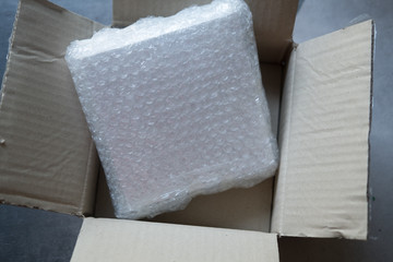 Parcel in brown box with bubble wrap for protection parcel product cracked
