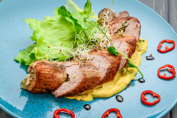 grilled meat with sauce and stewed vegetables on a wooden table
