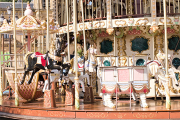 Old-fashioned wooden carousel with horses on a sunny day