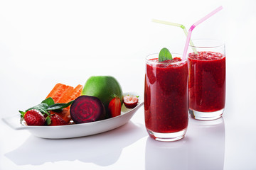 Detox smoothie from apple, beet, carrots, strawberry and spinach in a glass on a white background. Ingredients for a detox smoothie.  High key. Selective focus.