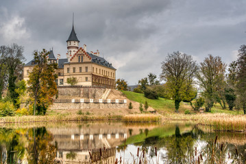 Fototapeta na wymiar Castle reflecting in lake below it in autumn, Czech Redun