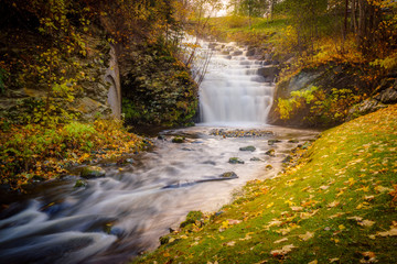 Waterfall cascade in a park in the city of Trondheim. Tourist attraction. Golden Norway in autumn.