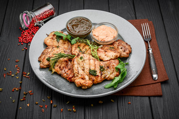 Tasty Grilled chicken fillet and chili peppers on a plate on the table. horizontal view from above