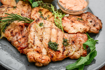 Tasty Grilled chicken fillet and chili peppers on a plate on the table. horizontal view from above