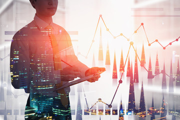 Businessman with clipboard in city, graph