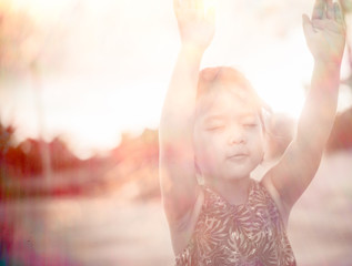 Little girl praying and raise hands in the morning for faith, spirituality and religion.sepia...