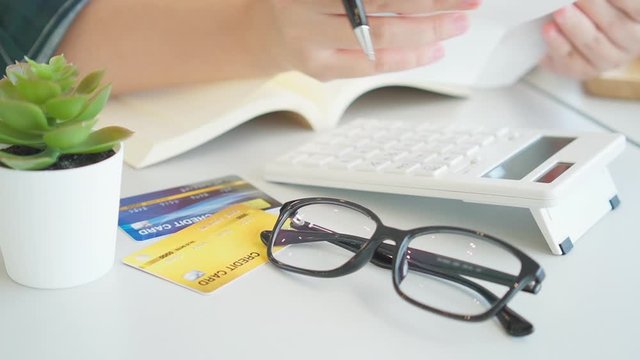 4k Asian women hands Calculate with a calculator Home incomes and expenses and savings, investment concepts, savings