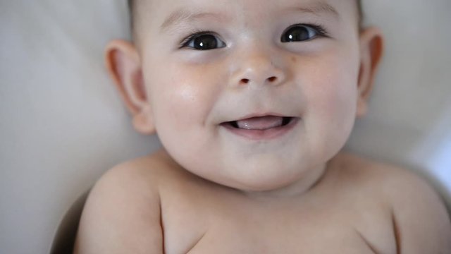 smiling portrait of cute happy baby with brown big eyes. Joyful childhood