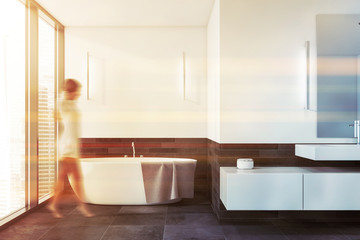 Woman walking in white and gray bathroom - Powered by Adobe