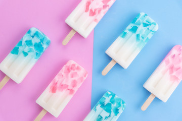 Homemade Ice cream sticks , popsicle , ice pop or freezer pop on blue and pink pastel colors background