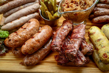 Grilled sausages with glass of beer on a wooden table