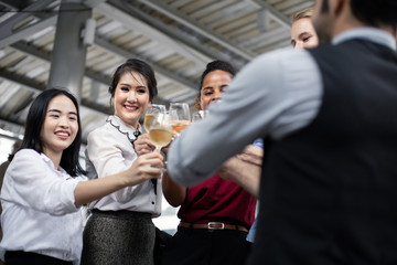 Group of business people celebrate by drinking wine.