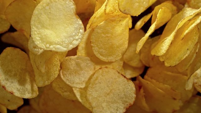 Super Slow Motion Shot of Potato Chips Flies After Being Exploded against Black Background, 1000fps.