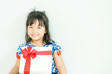 Little asian girl smile and holding red gift box on white background.child holding gift box.