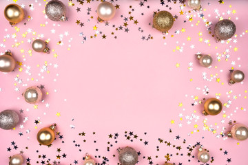 Festive pink background with gold and silver stars and Christmas balls. Flat lay, top view. Copy space for your text.